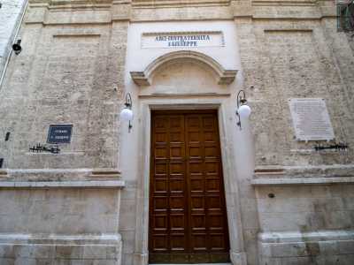 ...appare la piccola facciata del tempio. Molto semplice, si presenta con un prospetto tripartito da paraste con capitelli ed � divisa orizzontalmente in due ordini da una trabeazione. Nella parte inferiore le paraste poggiano su un�alta zoccolatura